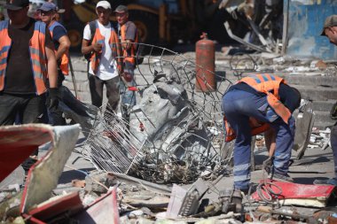 DNIPRO, UKRAINE - 08.24.20: bir Rus roketi Dnipro otobüs durağına çarptı. Otobüs durağı, dükkanlar ve ticaret kulübeleri yıkıldı. İşçiler hasarı temizler