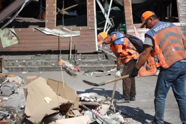 DNIPRO, UKRAINE - 08.24.20: bir Rus roketi Dnipro otobüs durağına çarptı. Otobüs durağı, dükkanlar ve ticaret kulübeleri yıkıldı. İşçiler hasarı temizler