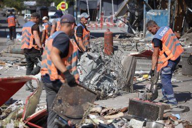 DNIPRO, UKRAINE - 08.24.20: bir Rus roketi Dnipro otobüs durağına çarptı. Otobüs durağı, dükkanlar ve ticaret kulübeleri yıkıldı. İşçiler hasarı temizler