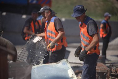 DNIPRO, UKRAINE - 08.24.20: bir Rus roketi Dnipro otobüs durağına çarptı. Otobüs durağı, dükkanlar ve ticaret kulübeleri yıkıldı. İşçiler hasarı temizler