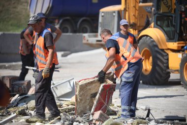DNIPRO, UKRAINE - 08.24.20: bir Rus roketi Dnipro otobüs durağına çarptı. Otobüs durağı, dükkanlar ve ticaret kulübeleri yıkıldı. İşçiler hasarı temizler