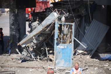 DNIPRO, UKRAINE - 08.24.20: bir Rus roketi Dnipro otobüs durağına çarptı. Otobüs durağı, dükkanlar ve ticaret kulübeleri yıkıldı. İşçiler hasarı temizler