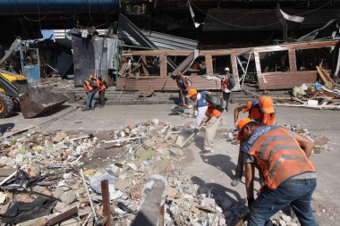 DNIPRO, UKRAINE - 08.24.20: bir Rus roketi Dnipro otobüs durağına çarptı. Otobüs durağı, dükkanlar ve ticaret kulübeleri yıkıldı. İşçiler hasarı temizler