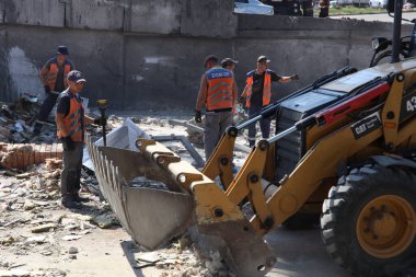 DNIPRO, UKRAINE - 08.24.20: bir Rus roketi Dnipro otobüs durağına çarptı. Otobüs durağı, dükkanlar ve ticaret kulübeleri yıkıldı. İşçiler hasarı temizler