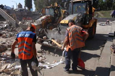 DNIPRO, UKRAINE - 08.24.20: bir Rus roketi Dnipro otobüs durağına çarptı. Otobüs durağı, dükkanlar ve ticaret kulübeleri yıkıldı. İşçiler hasarı temizler