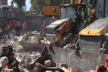 DNIPRO, UKRAINE - 08.24.20: bir Rus roketi Dnipro otobüs durağına çarptı. Otobüs durağı, dükkanlar ve ticaret kulübeleri yıkıldı. İşçiler hasarı temizler