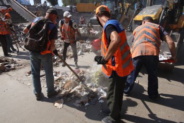 DNIPRO, UKRAINE - 08.24.20: bir Rus roketi Dnipro otobüs durağına çarptı. Otobüs durağı, dükkanlar ve ticaret kulübeleri yıkıldı. İşçiler hasarı temizler