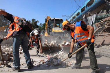 DNIPRO, UKRAINE - 08.24.20: bir Rus roketi Dnipro otobüs durağına çarptı. Otobüs durağı, dükkanlar ve ticaret kulübeleri yıkıldı. İşçiler hasarı temizler