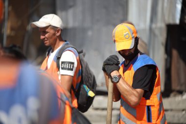 DNIPRO, UKRAINE - 08.24.20: bir Rus roketi Dnipro otobüs durağına çarptı. Otobüs durağı, dükkanlar ve ticaret kulübeleri yıkıldı. İşçiler hasarı temizler