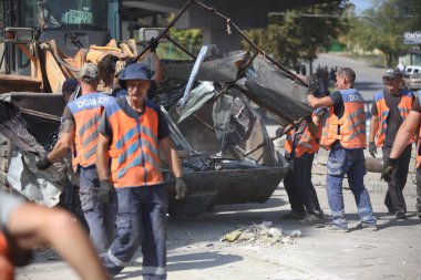 DNIPRO, UKRAINE - 08.24.20: bir Rus roketi Dnipro otobüs durağına çarptı. Otobüs durağı, dükkanlar ve ticaret kulübeleri yıkıldı. İşçiler hasarı temizler