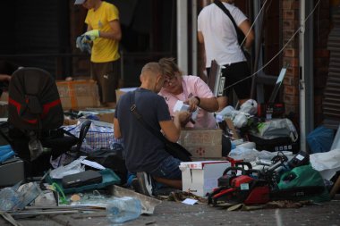 DNIPRO, UKRAINE - 08.24.20: bir Rus roketi Dnipro otobüs durağına çarptı. Otobüs durağı, dükkanlar ve ticaret kulübeleri yıkıldı. İşçiler hasarı temizler