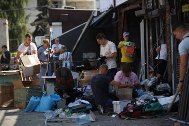 DNIPRO, UKRAINE - 08.24.20: bir Rus roketi Dnipro otobüs durağına çarptı. Otobüs durağı, dükkanlar ve ticaret kulübeleri yıkıldı. İşçiler hasarı temizler