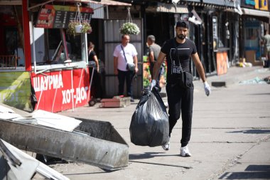 DNIPRO, UKRAINE - 08.24.20: bir Rus roketi Dnipro otobüs durağına çarptı. Otobüs durağı, dükkanlar ve ticaret kulübeleri yıkıldı. İşçiler hasarı temizler