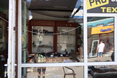 DNIPRO, UKRAINE - 08.24.20: bir Rus roketi Dnipro otobüs durağına çarptı. Otobüs durağı, dükkanlar ve ticaret kulübeleri yıkıldı. İşçiler hasarı temizler