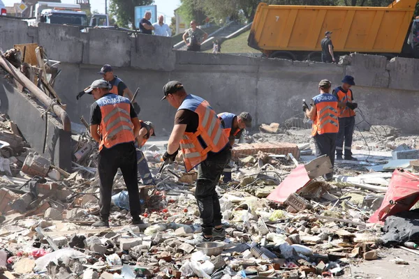 DNIPRO, UKRAINE - 08.24.20: bir Rus roketi Dnipro otobüs durağına çarptı. Otobüs durağı, dükkanlar ve ticaret kulübeleri yıkıldı. İşçiler hasarı temizler