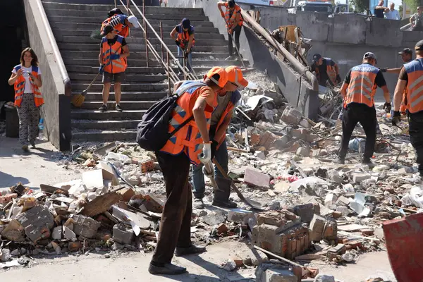 DNIPRO, UKRAINE - 08.24.20: bir Rus roketi Dnipro otobüs durağına çarptı. Otobüs durağı, dükkanlar ve ticaret kulübeleri yıkıldı. İşçiler hasarı temizler