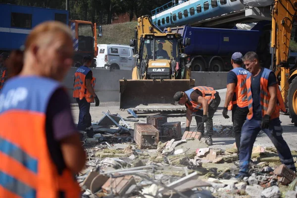 DNIPRO, UKRAINE - 08.24.20: bir Rus roketi Dnipro otobüs durağına çarptı. Otobüs durağı, dükkanlar ve ticaret kulübeleri yıkıldı. İşçiler hasarı temizler