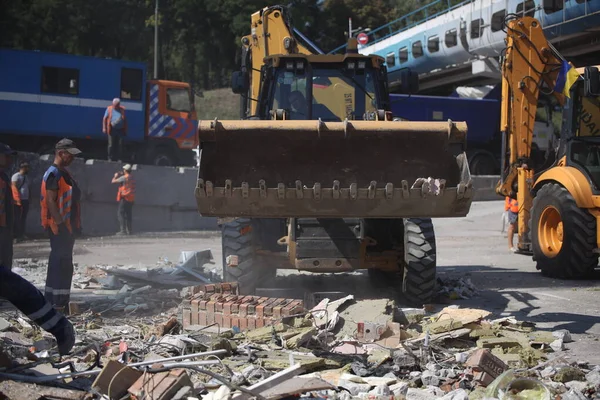 DNIPRO, UKRAINE - 08.24.20: bir Rus roketi Dnipro otobüs durağına çarptı. Otobüs durağı, dükkanlar ve ticaret kulübeleri yıkıldı. İşçiler hasarı temizler