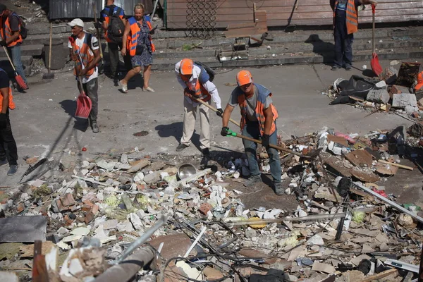 DNIPRO, UKRAINE - 08.24.20: bir Rus roketi Dnipro otobüs durağına çarptı. Otobüs durağı, dükkanlar ve ticaret kulübeleri yıkıldı. İşçiler hasarı temizler