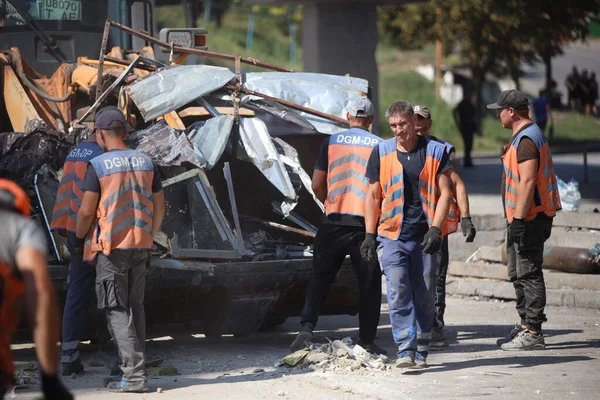 DNIPRO, UKRAINE - 08.24.20: bir Rus roketi Dnipro otobüs durağına çarptı. Otobüs durağı, dükkanlar ve ticaret kulübeleri yıkıldı. İşçiler hasarı temizler