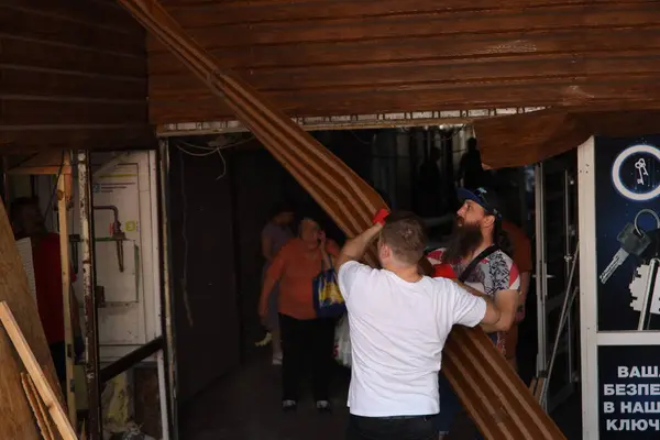 DNIPRO, UKRAINE - 08.24.20: bir Rus roketi Dnipro otobüs durağına çarptı. Otobüs durağı, dükkanlar ve ticaret kulübeleri yıkıldı. İşçiler hasarı temizler