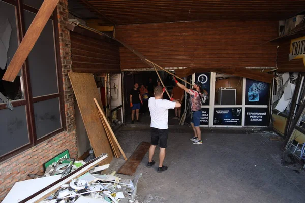 DNIPRO, UKRAINE - 08.24.20: bir Rus roketi Dnipro otobüs durağına çarptı. Otobüs durağı, dükkanlar ve ticaret kulübeleri yıkıldı. İşçiler hasarı temizler