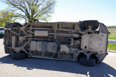 Trafik kazası. Araba devrildi. Araba çatıya yuvarlandı. Tekerlek çıktı. Kırık minibüs. Ters dönmüş minibüs.