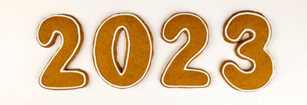 Stock image Gingerbread cookies in the form of numbers 2023 in the center on a white background. New year concept, top view, tiles