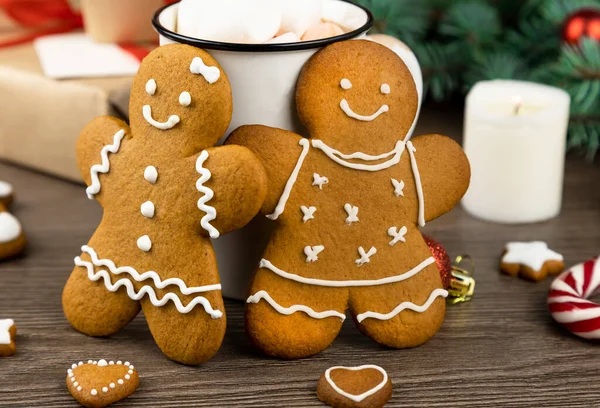 Gingerbread man and gingerbread woman on the background of Christmas decorations. Close up