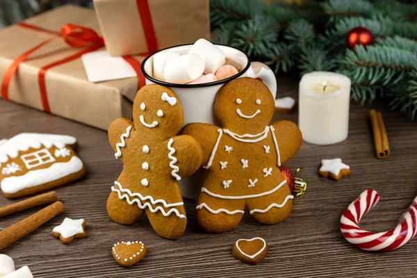 Noel süslemelerinin arka planında zencefilli adam ve zencefilli kurabiye kadın