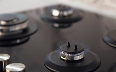Gas stove burner. Modern kitchen stove with blue flame burning