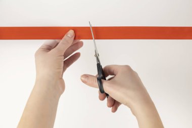 Bir kadının elindeki makas kırmızı bir kurdele kesti. Kurdele kesme töreni