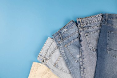 Mavi arka planda birçok farklı renkte kot serilmiştir.