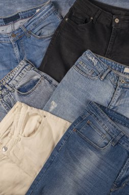 Jeans of different colors laid out on the table. Fashion concept