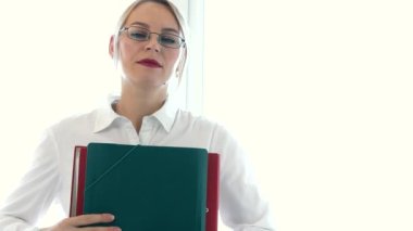 The female secretary gives the director folders with documents for perusal and signature. Business concept