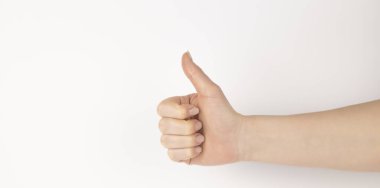 El hareketi, baş parmaklar yukarı, beyaz arka planda izole edilmiş. Dişi avuç içi, tasarımınız için boş olan bir şeyi işaret ediyor.