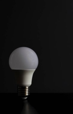 White LED lamp on a black background. The concept of saving electricity