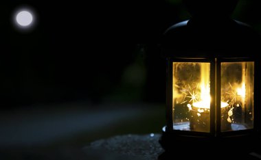 Ayla birlikte gece gökyüzünün arka planında yanan bir fener. Ramazan Bayramı