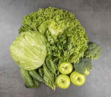 Gri arka planda meyve püresi için yeşil sebzeler. Yeşil sebze kavramı