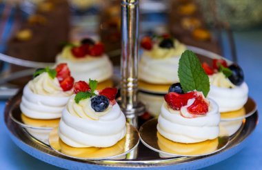 Böğürtlen ve çilekle çırpılmış kar beyazı bir krema bulutu. Pavlovs tatlısı. Çikolata konsepti