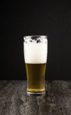 Karanlık bir arka planda bir bardak el yapımı bira. Bira yapma konsepti