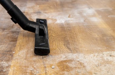 Kirli zemini süpüren elektrikli süpürgenin yakın çekimi.