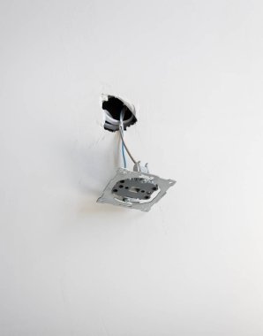 Duvardan sökülmüş metal bir soket çıkıyor. Bir dairede yenileme konsepti