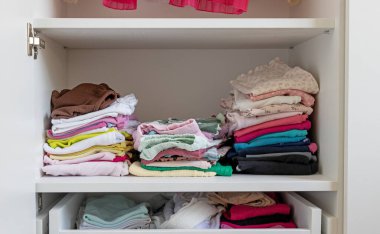 Dolapta katlanmış çocuk kıyafetleri, çocuk kıyafetleri deposu.