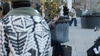 Barselona, İspanya - Kasım 2021: Sokak müzisyenlerinin portresi gitar çalıyor ve arka planda turistler olan Plaza Catalunya 'da şarkı söylüyor
