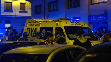 24 Aralık 2022 'de Pamplona Navarra şehrinde düzenlenen festival alayı. Bask ülkesi. Geceleri kalabalığın arasında yanıp sönen ışıkları olan bir ambulans.