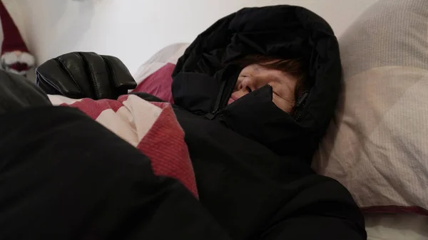 sleeping in a jacket with a hood under the covers