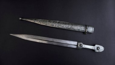          antique, silver dagger with scabbard on a black background.                        