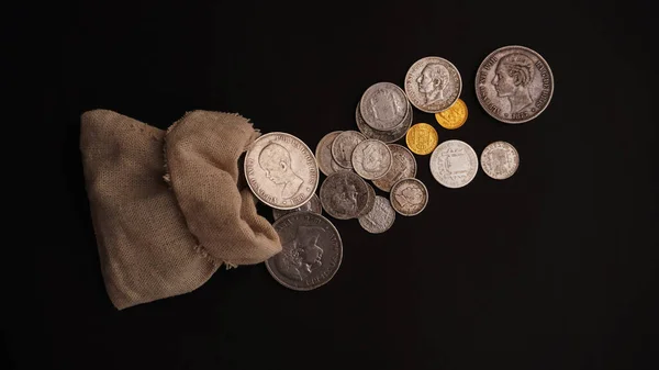 treasure, treasure, pouch with gold and silver coins on a black background