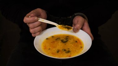    Elleri kelepçeli bir mahkumun elinde çorba konsepti var: Özgürlükten yoksun yerlerde yemek. Hapishane                             